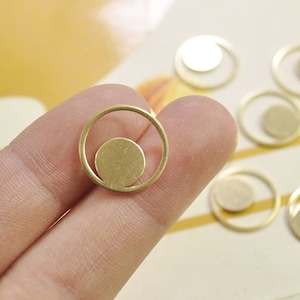 Puede incluir: Encanto de metal dorado en forma de c&iacute;rculo con un c&iacute;rculo m&aacute;s peque&ntilde;o en el interior. El encanto tiene un dise&ntilde;o minimalista y es perfecto para la elaboraci&oacute;n de joyas.