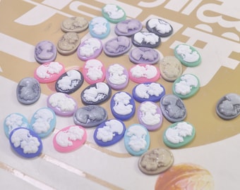 May include: Assortment of colorful cameo-style resin cabochons in various shades of pink, purple, blue, green, and gray. Each cabochon features a raised design of a woman's profile.