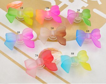 May include: Eight colorful translucent plastic bows with a gradient effect. The bows are numbered 1 through 8.