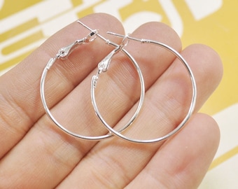 May include: A pair of silver hoop earrings. The earrings are simple and elegant, and they would be a great addition to any jewelry collection.