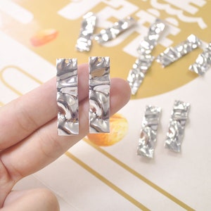 May include: Silver-toned metal earring blanks with a textured, wavy surface. The blanks are rectangular in shape and have a hole at the top for attaching earring wires.