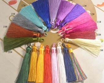 May include: Assortment of 20 colorful silk tassels with a variety of colors including red, blue, green, yellow, pink, purple, orange, white, and black. The tassels are numbered 1 through 20.