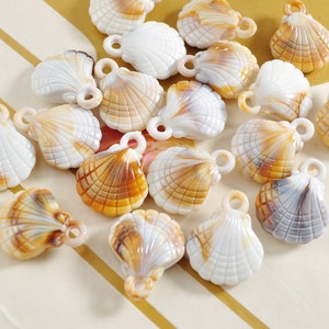 May include: A collection of white and brown seashell charms with a hole at the top for hanging. The charms are made of plastic and have a realistic seashell design.