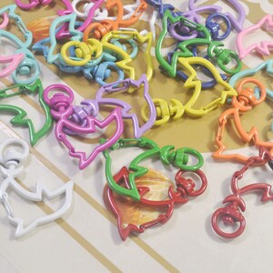 Puede incluir: Un conjunto de llaveros de metal de colores con forma de pez. Los llaveros son de varios colores, incluyendo rosa, morado, verde, amarillo, naranja, rojo y azul.