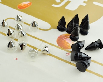 May include: Two sets of silver and black pyramid-shaped studs with clear plastic bases. The silver studs are labeled "1#" and the black studs are labeled "2#"