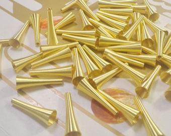 May include: A large group of gold metal cone-shaped beads. The beads are made of coiled wire and have a shiny finish.