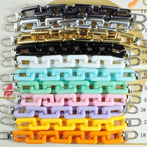 May include: Eleven different coloured plastic chain straps with silver clasps. The chains are numbered 1 through 11.