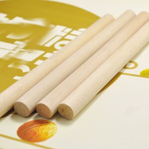 Puede incluir: Cuatro listones de madera natural, de aproximadamente 30 cm de largo, est&aacute;n dispuestos en una pila sobre una superficie dorada y blanca. Los listones son lisos y tienen un color marr&oacute;n claro.