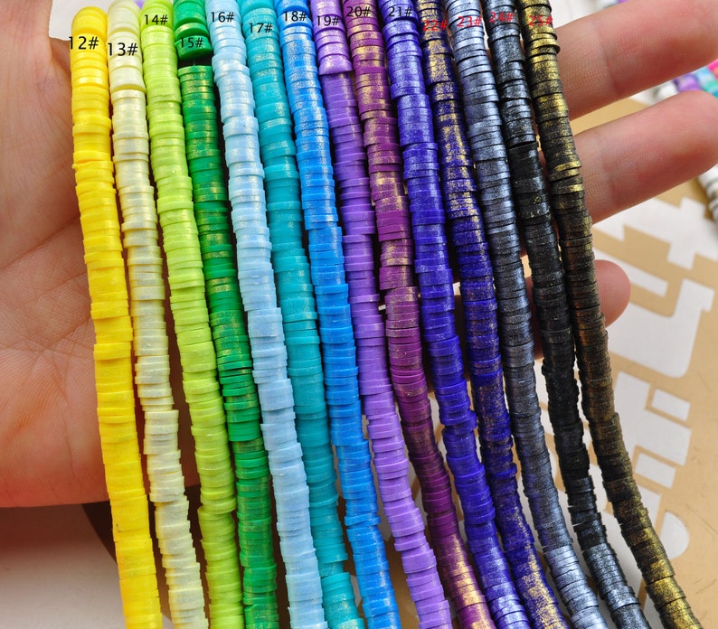 Pu&ograve; includere: Un set di 12 fili di perline rotonde, piatte e colorate con accenti dorati. Le perline sono disposte in un motivo arcobaleno, a partire dal giallo e terminando con il nero. Le perline sono numerate da 12 a 23.