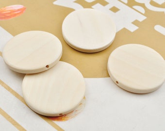 May include: Four round, unfinished wooden discs with a hole in the center. The discs are light brown and have a smooth surface.