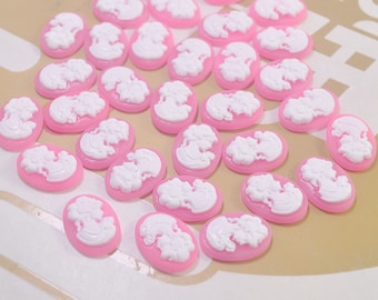 May include: A collection of pink oval-shaped buttons with white cameo designs.