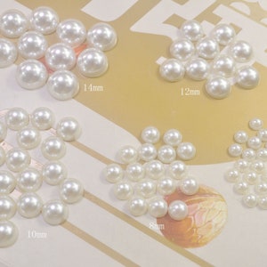 Può includere: Assortimento di decorazioni di perle bianche in varie dimensioni, tra cui 6 mm, 8 mm, 10 mm, 12 mm e 14 mm.