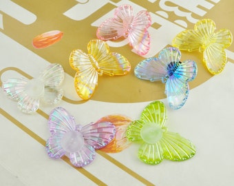 May include: Assortment of iridescent butterfly shaped embellishments in various colors, including pink, yellow, blue, and purple. The butterflies are made of clear plastic with a shimmering finish.