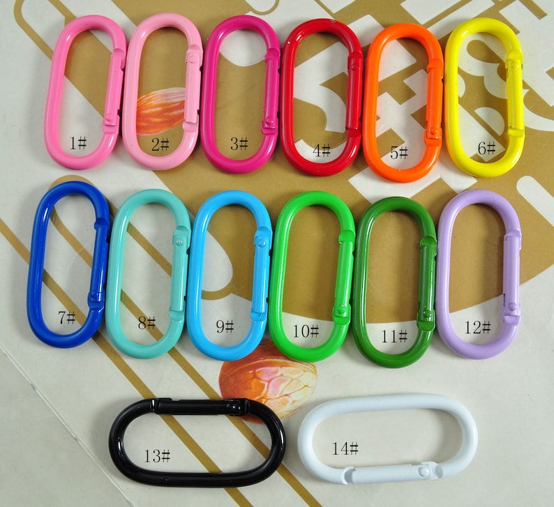 May include: Assortment of 14 colorful metal key rings in various sizes. The key rings are numbered 1 through 14. The key rings are oval shaped and have a spring-loaded clasp.