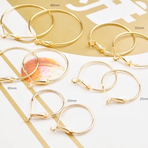 May include: Six gold hoop earrings of different sizes, ranging from 20mm to 40mm in diameter. The earrings are displayed on a white surface with measurements labelled in millimetres.