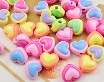 May include: A collection of colorful heart-shaped beads in various shades of pink, blue, yellow, green, and orange. Each bead has a hole for stringing. These beads are suitable for jewelry making and craft projects.