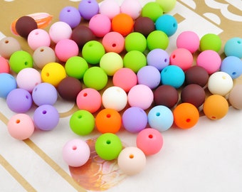 May include: A large collection of colorful silicone beads in various shades of pink, blue, green, yellow, orange, brown, and white. The beads are round and smooth, and they are perfect for making jewelry or other crafts.