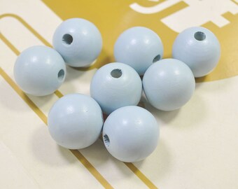 May include: A set of eight light blue wooden beads with a hole in the center of each bead. The beads are round and smooth.