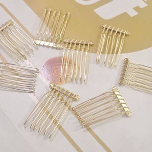May include: A set of ten gold metal hair combs. The combs are small and have a rectangular shape. They are ideal for adding a touch of elegance to any hairstyle.