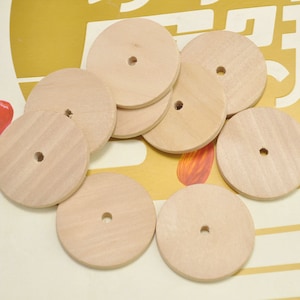 May include: A set of eight unfinished wooden circles with a hole in the center. The circles are all the same size and are arranged in a random pattern.