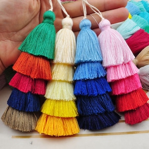 Puede incluir: Surtido de flecos multicolores de varias capas con una variedad de colores, incluyendo verde, naranja, rojo, amarillo, azul y rosa.