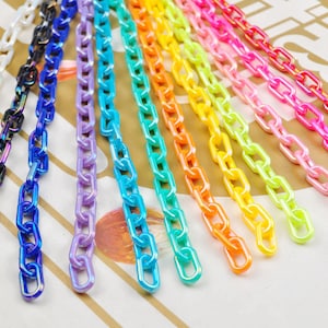 May include: Assortment of colorful plastic chains in various bright colors, including white, blue, purple, green, yellow, orange, pink, and red.