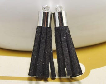 May include: Two black suede tassels with silver metal caps and loops. The tassels are approximately 2 inches long.