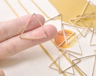 May include: A group of gold-colored triangle-shaped metal frames. The frames are about 1 inch in size and have a smooth, polished finish.