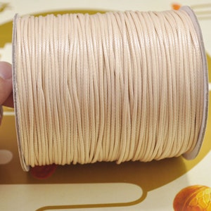 Può includere: Un rotolo di cordoncino di cotone cerato color crema.