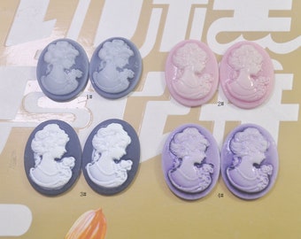 May include: Six oval-shaped cameo pendants with white figures on a colored background. The pendants are in pairs of two, with each pair having a different color: light blue, pink, black, and purple. The pendants are labeled with numbers 1 through 4.