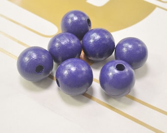 May include: Eight purple wooden beads with a hole in the center. The beads are round and smooth.