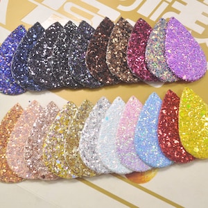 Pode incluir: Conjunto de 18 peças de tecido de glitter em forma de lágrima em várias cores, incluindo ouro, prata, rosa, azul, vermelho e roxo. As peças de tecido medem aproximadamente 5 cm de comprimento e 2,5 cm de largura.