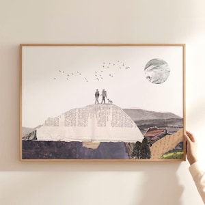 May include: A framed collage art print featuring a mountain landscape made of torn book pages and textured paper. Two figures and a small dog stand on a peak under a circular moon, with a flock of birds flying above in a minimalist composition.