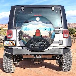 以下が含まれることがあります： 風景と座っている人が描かれたスペアタイヤカバー。カバーには「To see the world, things dangerous to come to... That is the purpose of life.」という引用句が書かれています。