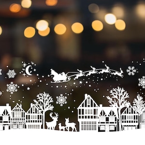 Può includere: Silhouette bianca di un villaggio natalizio con case, alberi e una slitta con Babbo Natale e renne che volano sopra. Lo sfondo è un'immagine sfocata di luci.
