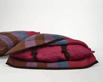 Handwoven cushion of linen. Weaving many-coloured, mauve, brown, blue and raspberry. One of a kind and original weaving.