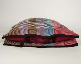 Handwoven cushion of linen. Weaving many-coloured mauve, brown, blue and raspberry. One of a kind and original weaving.