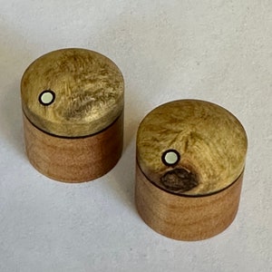 May include: Two wooden boxes with a light brown finish and a white circle inlay on the top. The boxes are made of wood with a natural grain pattern.