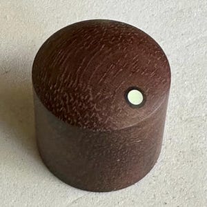 以下が含まれることがあります： 中央に白い点がついた濃い茶色の木製ノブ