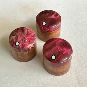 May include: Three small wooden boxes with pink and brown marbled lids. Each lid has a white circle in the center.