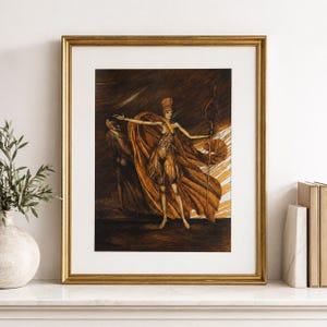 May include: A framed print featuring a stylized illustration of a woman in flowing robes, holding a staff. The artwork is rendered in shades of brown and gold, with a dramatic, ethereal quality. The frame is gold.