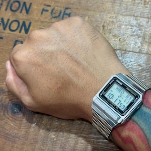 May include: A silver-tone Casio Data Bank digital watch with a rectangular face, metal link strap, and black bezel accents. The digital display shows the text CASIO, DATA BANK, TELEMEMO 50, and the time 10:17:59 with the date WED 31 2-11.