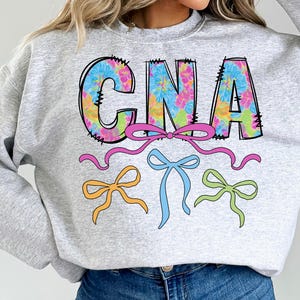 May include: A set of three ceramic mugs with a speckled, cream-colored glaze. Each mug features a different hand-painted floral design in shades of blue, green, and yellow. The mugs are approximately 4 inches tall.