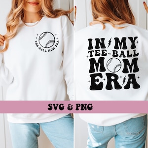 May include: White sweatshirt with a black baseball graphic and the text "TEE-BALL MOM ERA" on the front and the text "IN MY TEE-BALL MOM ERA" on the back.