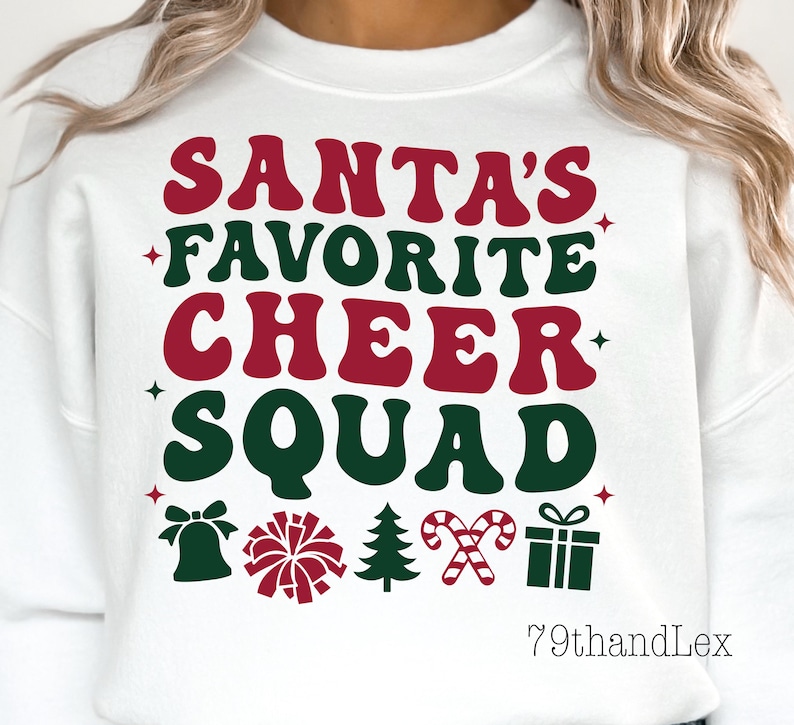 May include: White sweatshirt with the text "SANTA'S FAVORITE CHEER SQUAD" in red and green. The design includes festive icons like a bell, pom-pom, Christmas tree, candy canes, and a gift box. The brand name "79thandLex" is at the bottom.