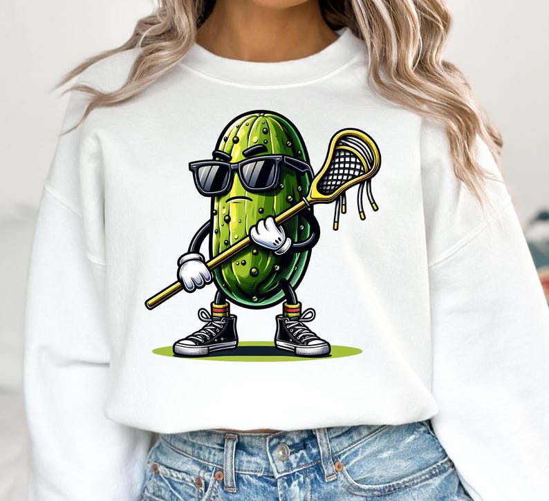 May include: White cropped sweatshirt with a cartoon pickle wearing sunglasses and holding a lacrosse stick. The pickle is green with a yellow and green striped sock.