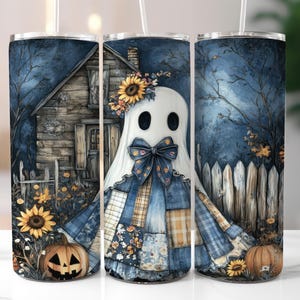 May include: A Halloween-themed tumbler featuring a ghost character with a blue patchwork outfit and a sunflower crown. The design includes a spooky house, pumpkins, and a wooden fence, all set against a dark blue background.