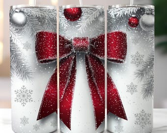 May include: A set of three stainless steel tumblers with a festive winter design. Each tumbler features a large red bow with a snowy effect, silver ornaments, snowflakes, and pine branches against a white background. The tumblers have clear straws.