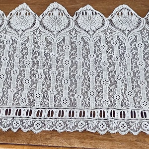 May include: White lace trim with a scalloped edge and a repeating floral pattern.