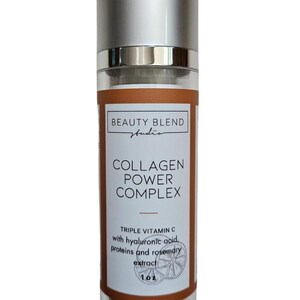 以下が含まれることがあります： シルバーのキャップと茶色のラベルが付いたスキンケア製品のボトル。「BEAUTY BLEND studio」と「COLLAGEN POWER COMPLEX」と書かれています。「TRIPLE VITAMIN C」とヒアルロン酸、タンパク質、ローズマリーエキスも記載されています。ボトルには29.57 mlの製品が含まれています。